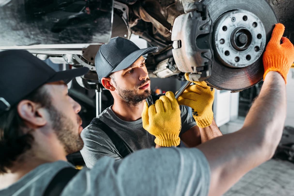 Mechanics working on a vehicle in a service bay